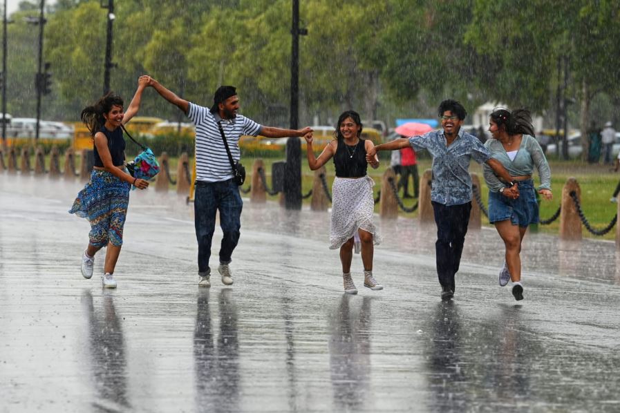 दिल्ली में बारिश के बीच कर्तव्य पथ पर मौजीद पर्यटक